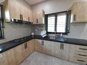 a kitchen with wooden cabinets and a sink and a window at Teratak Assofiyya 4 Bilik in Sungai Petani