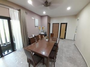 a dining room with a wooden table and chairs at Teratak Assofiyya 4 Bilik in Sungai Petani +4 photos