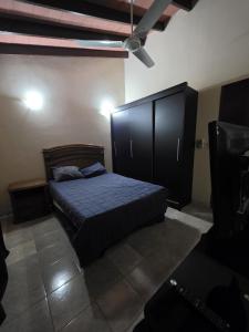 a bedroom with a bed and a large black cabinet at Lemai Inmobiliaria in Barrio Caacupé Mí