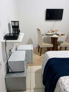 a bedroom with a coffee maker and a table with a bed at Royalties Flats in Petrolina