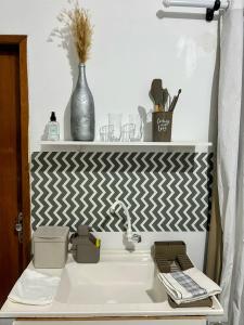 a bathroom with a white sink and a white wall at Royalties Flats in Petrolina +29 photos