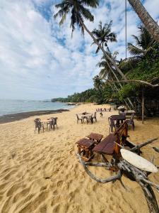 a beach with tables and chairs on the sand at Sea Breeze Heaven in Tangalle