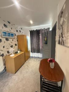 a living room with a wooden table and a desk at Eastern Bridge House in Spinney Hill