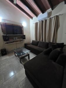 a living room with a couch and a tv at Lemai Inmobiliaria in Barrio Caacupé Mí