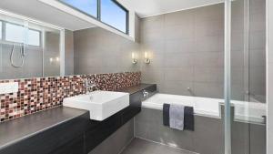 a bathroom with a sink and a bath tub at Beach Serenity in Sunderland Bay