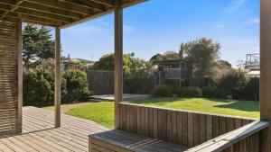 a wooden deck with a view of a yard at Beach Serenity in Sunderland Bay
