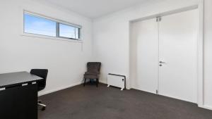 an empty room with a desk and a door at Beach Serenity in Sunderland Bay