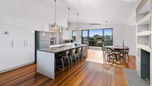 a kitchen with a counter and a table in it at Beach Serenity in Sunderland Bay