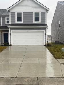 a house with a white garage door on a driveway at Inner Haven Family Homes in Indianapolis