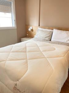 a large white bed in a bedroom with a window at Apt 1012 Conforto aconchego e vibe acolhedora in Santa Maria +13 photos