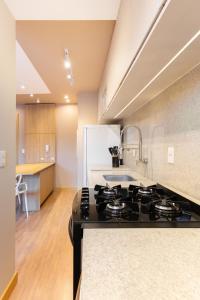 a kitchen with a black stove top in a kitchen at Apt 1012 Conforto aconchego e vibe acolhedora in Santa Maria