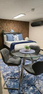 a bedroom with a bed and a glass table and chairs at Los Roires Beach Apartments in Fajardo
