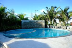 a swimming pool in a yard with palm trees at Mula De La Paz in Zambales