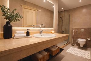 a bathroom with a sink and a toilet at Elegant Hydepark Apt With Garden in New cairo