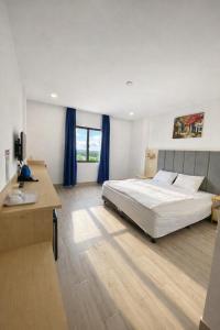 a large bedroom with a large bed and a desk at HT Hotel in Xuyên Mộc