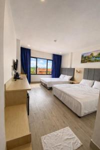 a hotel room with two beds and a television at HT Hotel in Xuyên Mộc +29 photos