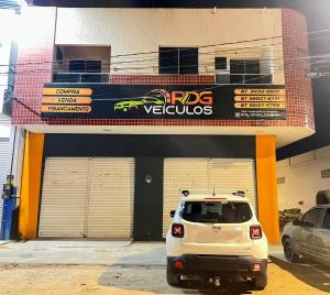 a white car parked in front of a garage at Royalties Flats in Petrolina