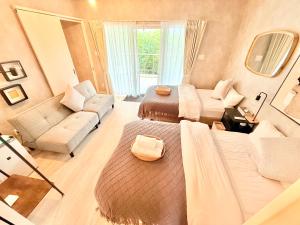 a large room with a bed and a couch and a chair at Plus Life Shiraho A号室 in Ishigaki Island