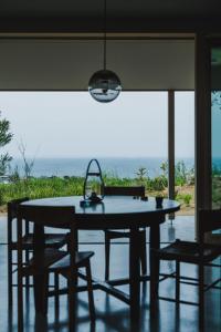 a kitchen table and chairs with a view of the ocean at SANU 2nd Home CURRENT Awajishima in Awaji +66 photos