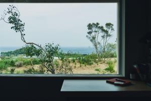 a window in a room with a view of the ocean at SANU 2nd Home CURRENT Awajishima in Awaji