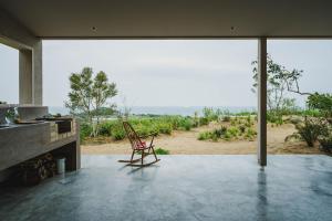 a chair in a room with a view of a field at SANU 2nd Home CURRENT Awajishima in Awaji