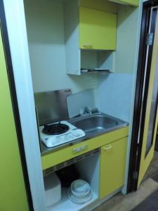a small kitchen with a sink and a stove at フレクション大工町 in Miyazaki