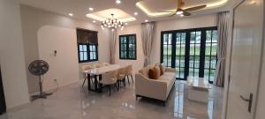 a dining room with a table and chairs and a ceiling fan at Villa NovawoRld Phan Thiết in Bình Sum