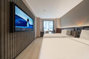 a hotel room with two beds and a flat screen tv at Atour X Hotel Chengdu Qingbaijiang Wanda in Chengdu