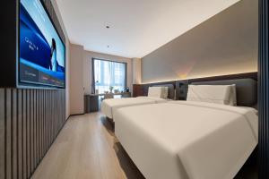 a hotel room with two beds and a flat screen tv at Atour X Hotel Chengdu Qingbaijiang Wanda in Chengdu