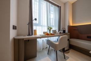 a room with a desk with a chair and a window at Atour X Hotel Chengdu Qingbaijiang Wanda in Chengdu