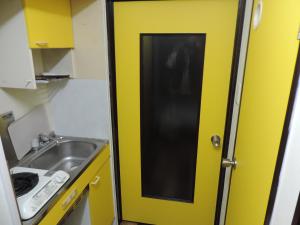 a yellow door in a kitchen next to a sink at フレクション大工町 in Miyazaki +74 photos