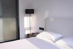 a bedroom with a white bed and a lamp at Wave Nest 汐宿 in Chongqing +27 photos