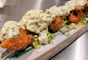 a plate of food with fried chicken and salad at GuestHouseさがら丸 in Niijimamura