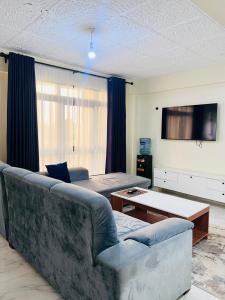 a living room with a couch and a tv at Legoland Residence in Migori