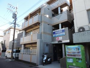 a building with a motorcycle parked in front of it at フレクション大工町 in Miyazaki