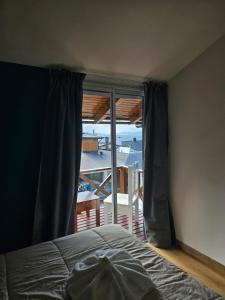 a bedroom with a bed and a view of the ocean at Los Dones Departamentos DAT in San Carlos de Bariloche