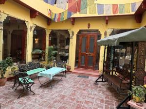 a building with a patio with chairs and a table at Udai Niwas - Bikaner in Bikaner