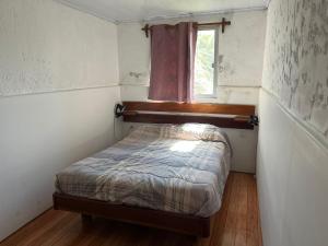 a small bedroom with a bed and a window at Carranca TH5 in Costa Azul
