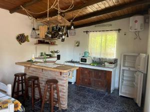 a kitchen with a counter and some stools in it at Carranca TH5 in Costa Azul