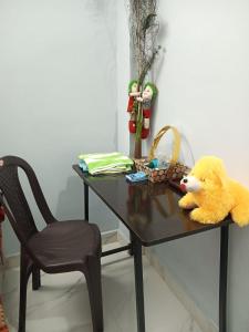 a table with a yellow teddy bear and a chair at Independent homestay DDN in Dehradun