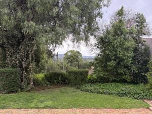a garden with trees and a brick walk way at Hekpoort Rorymi Guest farm in Hekpoort
