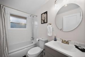 a bathroom with a sink and a toilet and a mirror at King Bed 1BDR Stadium District in Tacoma +34 photos