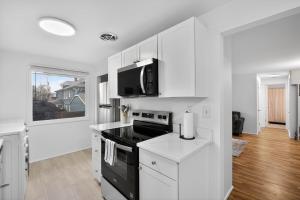 a kitchen with white cabinets and a black stove top oven at King Bed 1BDR Stadium District in Tacoma