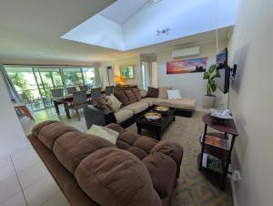 a living room with a couch and a table at Rainforest Cottage in Port Macquarie
