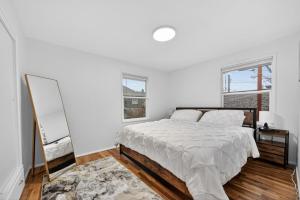 a white bedroom with a bed and a mirror at King Bed 1BDR Stadium District in Tacoma