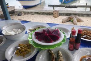 a table with plates of food on top of it at NATA homestay in Banggai