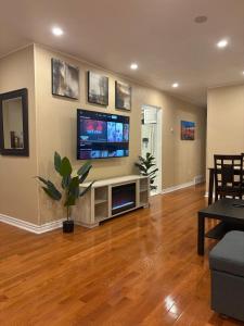 a living room with a flat screen tv on a wall at Tamuna's Home in Hamilton