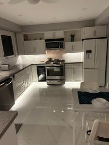 a kitchen with white cabinets and a table in it at Tamuna's Home in Hamilton