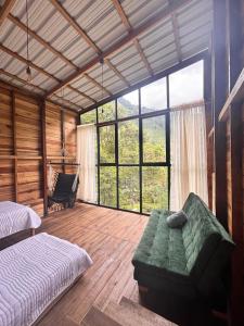 a bedroom with a bed and a couch and a large window at Cabañas AlmA Rural Ibagué in Ibagué +23 photos