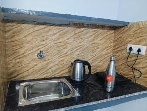 a kitchen counter with a sink and a tea kettle at Independent homestay DDN in Dehradun